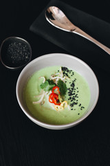 Delicious green spicy soup in white bowl