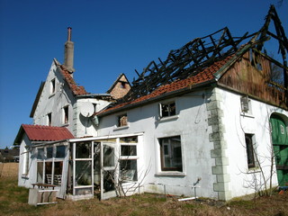 Ausgebranntes altes Landhaus vor strahlend blauem Himmel im Sonnenschein in der Provinz in...