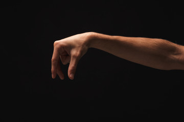 Male hand picking up something, cutout on black