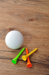 A golf ball with tee's isolated on a wooden background