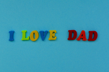 colorful text  'i love dad"  of magnetic letters on blue paper background