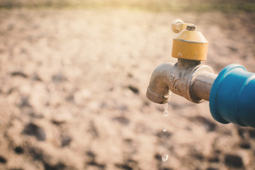 Faucet on cracked dry ground , concept drought and shortage of water