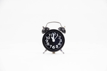 Closeup the black alarm clock with white numbers,put at the middle of  white background.it's eleven o'clock on the dial