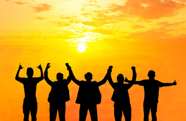 They are standing and show hand together.They are enjoying and also they are watching the evening glow together. They are happy in good time.Photo concept for Silhouetted and team work.