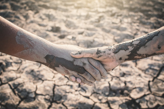 Human hands helping on cracked dry ground , Concept drought and shortage of water crisis