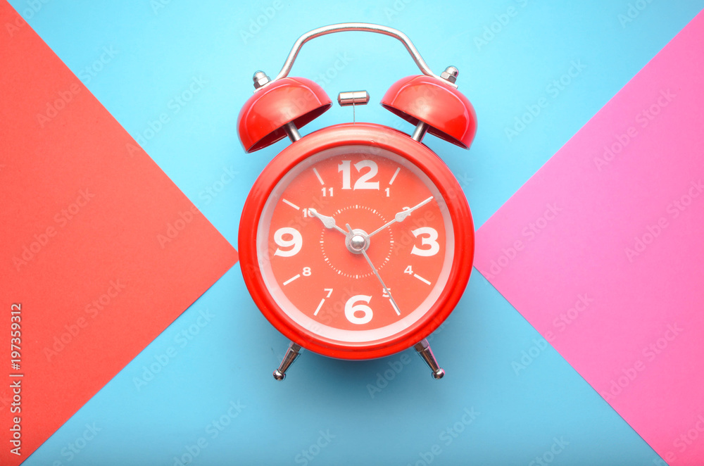 Wall mural clock on pink, red and blue background.