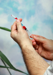 The doctor dials medicine into the syringe to make an injection.