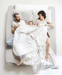 Obraz na płótnie Canvas Top view of happy family with one newborn child in bedroom.