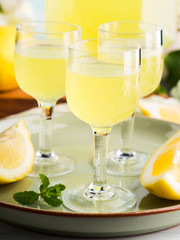 Home made limoncello served in stemmed glasses. Summer still life