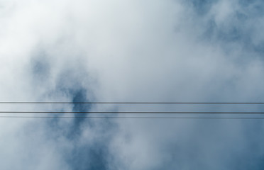 Wires and the cloudy sky