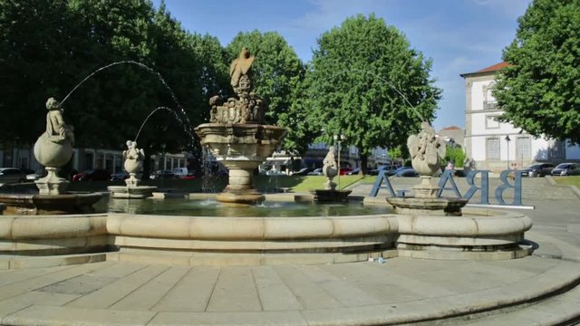 Fountain in Praca do Municipio or Town Hall Square in Braga downtown, North of Portugal. Braga urban cityscape, one of the oldest cities of Portugal. Sunny day with blue sky.