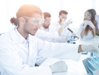 Scientists working with a microscope and make notes in the workp