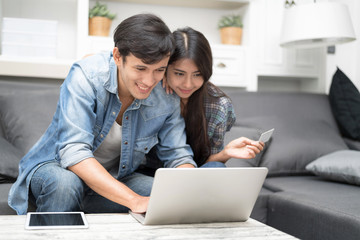 In Selective Focus Of Happy Lover Couple Holding White Credit Card In Hand While Using Laptop Computer Shopping Online.