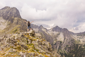 Fototapeta na wymiar Tatry krajobraz gór z nadchodzącą burzą. Kobieta ciesząca się ze zdobycia górskiego szczytu.
