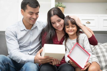 Happy Family spending time together at home.In selective focus of lovely gift box for mother's day.