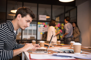 Serious businessman is working with laptop.
