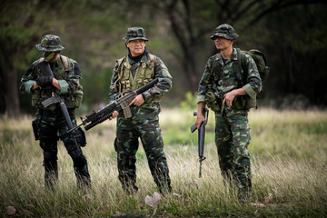 Squad of soldiers patrolling across the forest area.