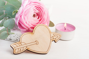 Pink buttercup flower with wooden heart