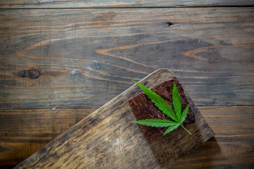 marijuana leaf on a marijuana brownie on wooden table