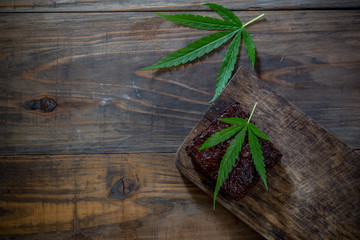 marijuana leaf on a marijuana brownie on wooden table