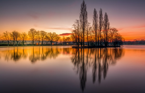 Pontefract Park Lake and reflection on water at sunrise, West Yorkshire, UK