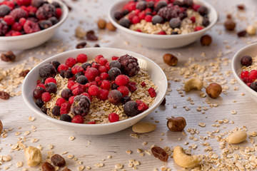Oatmeal, nuts, woody fruit on a wooden background, ingredients, healthy food