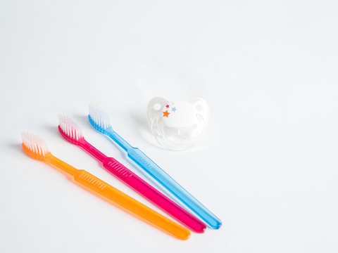 Two toothbrushes in a glass with dummy on a white background