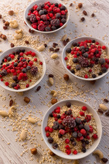Oatmeal, nuts, woody fruit on a wooden background, ingredients, healthy food