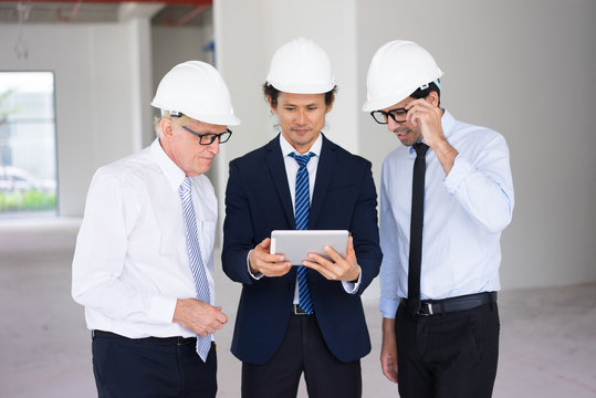 Busy architects examining electronic blueprint