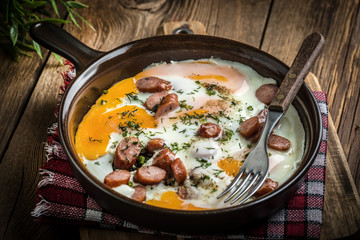 Tasty cooked egg with chopped sausages.