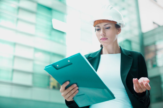 Woman architector in suit and hat is dissatisfieded of documents with project