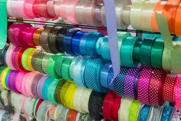Colored satin ribbons on the counter of the store. Needlework