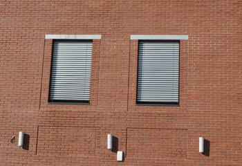 Dwa okna na ceglanej ścianie
