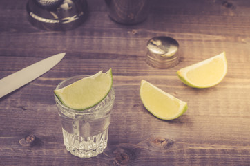 glasses of tequila with a lime/preparation of shot with a lime in a shaker. Top view