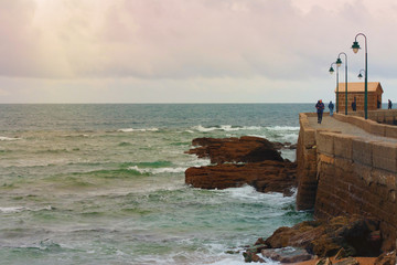 an elderly man makes a run along the waterfront.