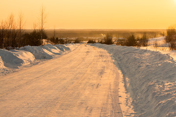 snow-covered road at sunset