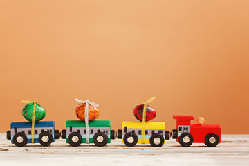 Concept Happy Easter Holiday -colorful train carrying eggs on blue background