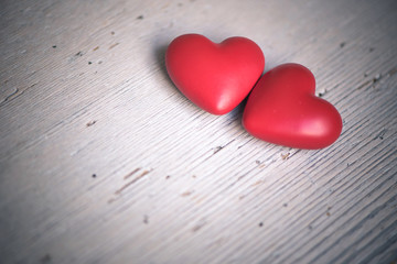 zwei rote Herzen auf grauem Holz für Grußkarte
