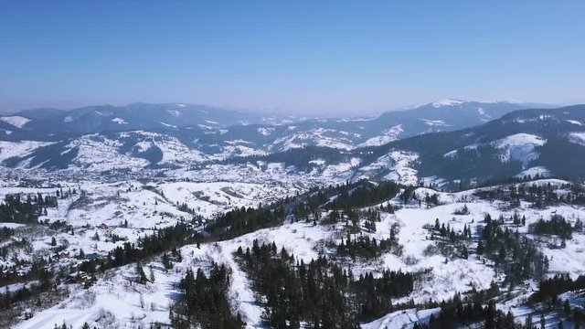 Aerial. Winter time in mountains hills. Flight with decrease 