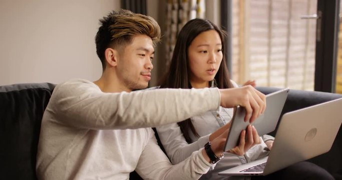 4K Annoying guy getting on girlfriend's nerves while she tries to work on laptop