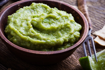 Fresh guacamole dip with lime juice and handmade nachos