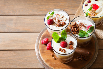 Dessert with berries, jelly, cream, nuts and mint leaf on a wooden cutting board