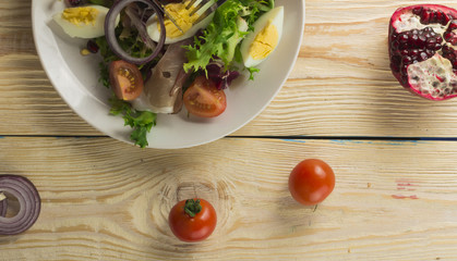 Fresh salad with mixed greens and cherry tomato in bowl on wooden background