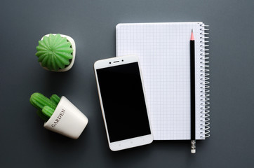 blank notebook with smartphone on grey office desktop
