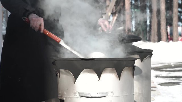 the chef lifts the lid and stirs