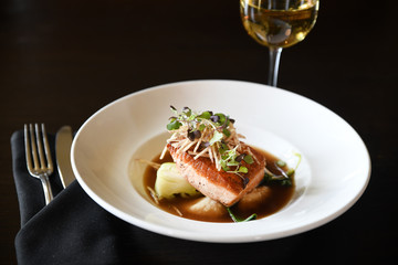 Salmon entree on plate with utensils