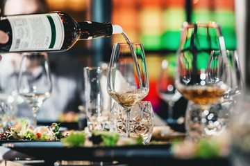 sommelier pouring wine into glass at wine tasting