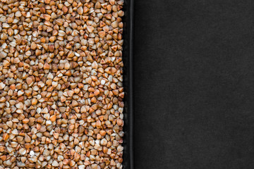 Buckwheat Grains in the Plate and Black Background With Free Space