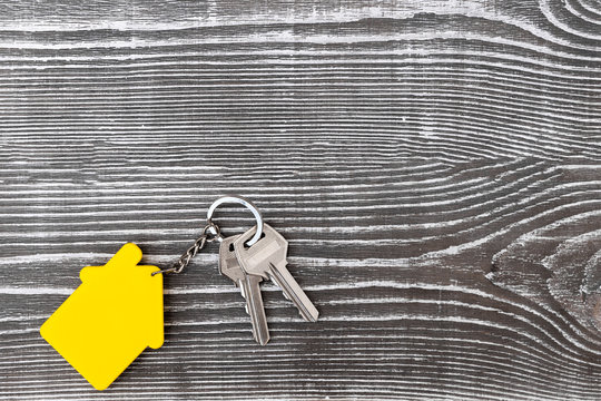 keys from the living space with a keychain in the form of a house on the background of a wooden table. sale.
