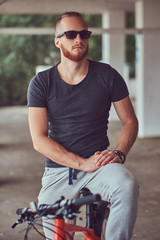 A handsome redhead male with a stylish haircut and beard dressed